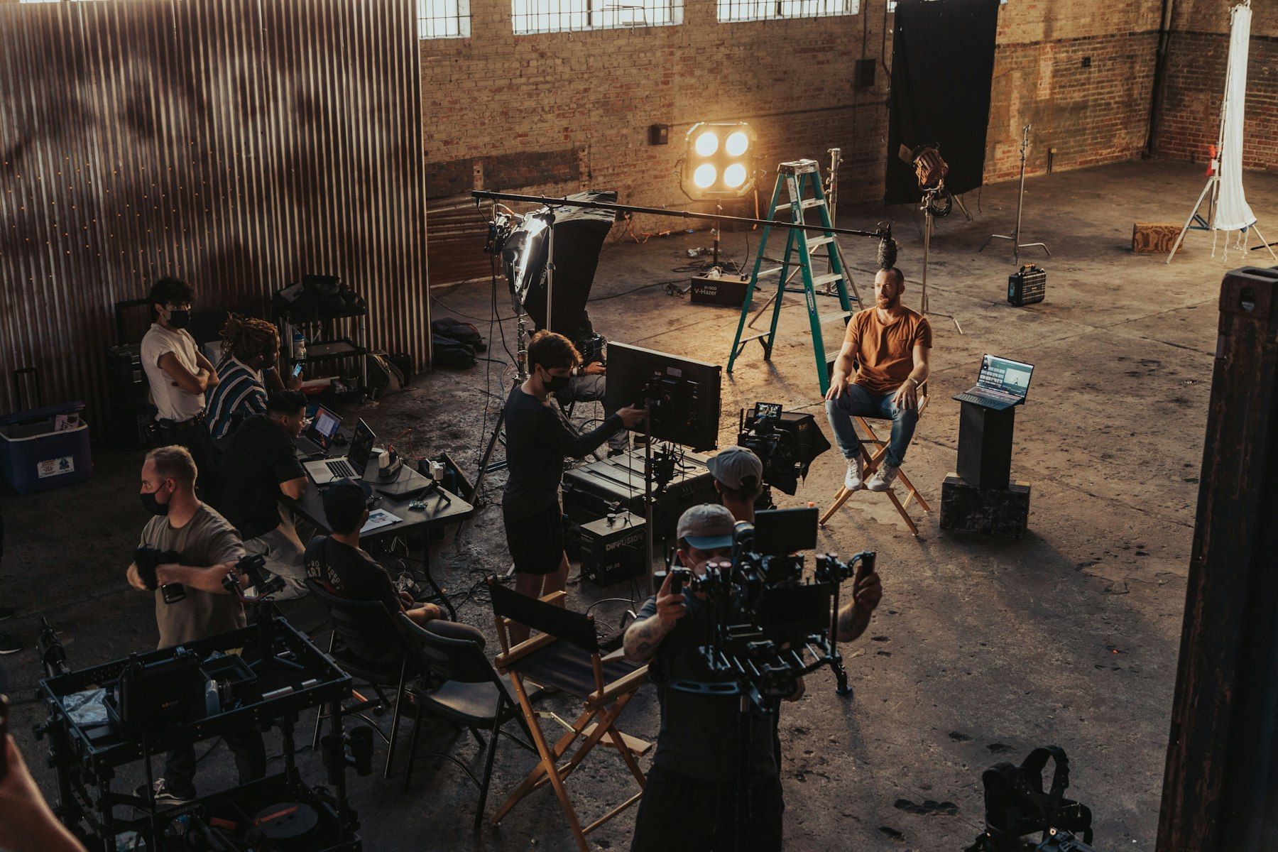 Film crew at work on a stage with lights and director chairs